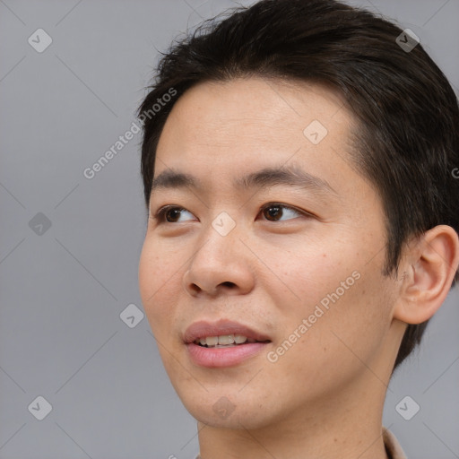Joyful asian young-adult male with short  brown hair and brown eyes