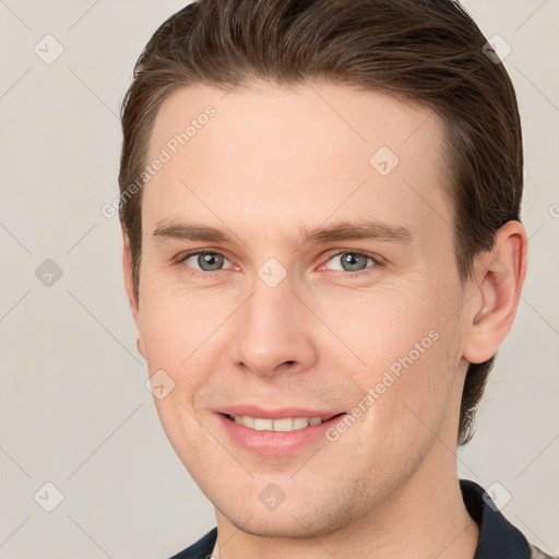 Joyful white young-adult male with short  brown hair and grey eyes