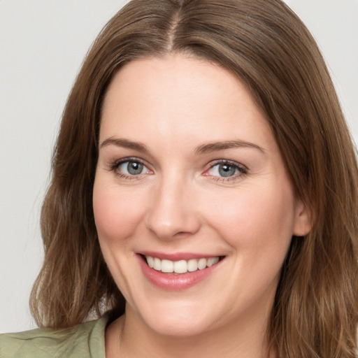 Joyful white young-adult female with long  brown hair and green eyes