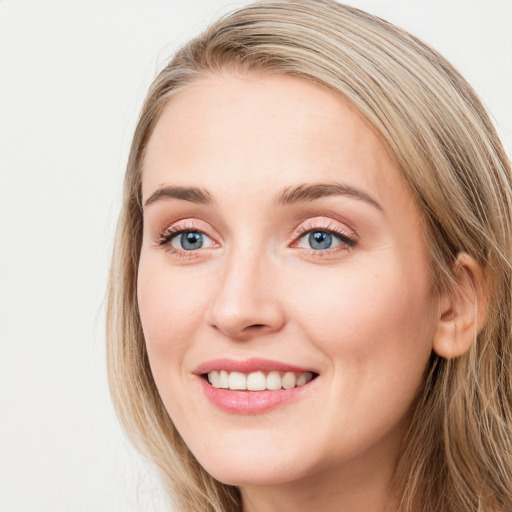 Joyful white young-adult female with long  brown hair and blue eyes