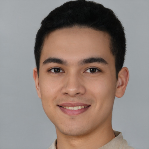 Joyful latino young-adult male with short  brown hair and brown eyes