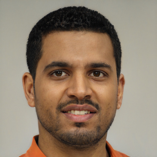 Joyful black young-adult male with short  black hair and brown eyes