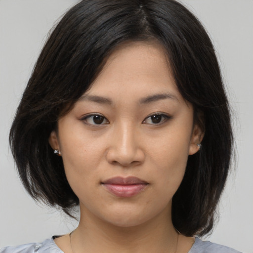Joyful asian young-adult female with medium  brown hair and brown eyes