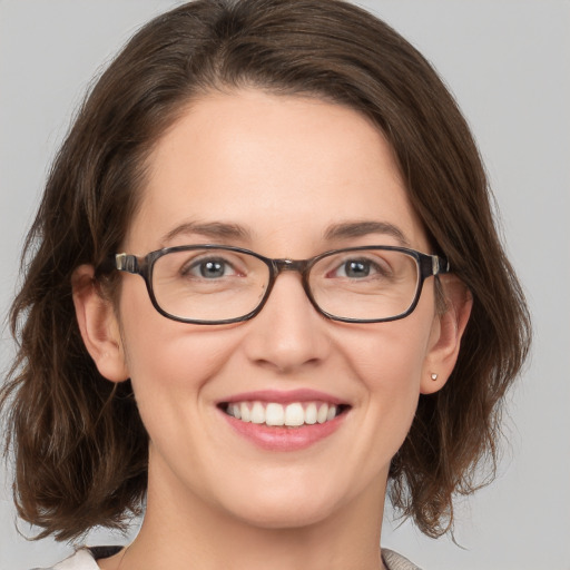 Joyful white young-adult female with medium  brown hair and green eyes