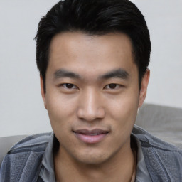 Joyful asian young-adult male with short  black hair and brown eyes