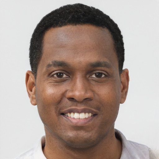 Joyful black young-adult male with short  black hair and brown eyes