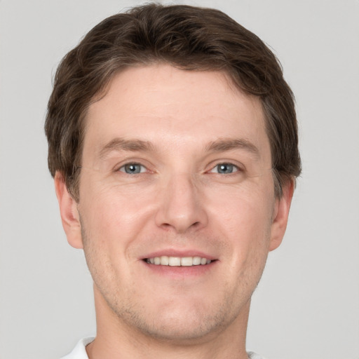 Joyful white adult male with short  brown hair and grey eyes