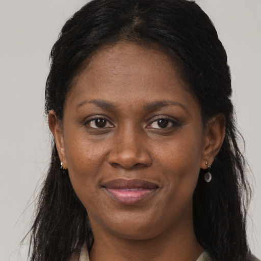 Joyful black adult female with long  brown hair and brown eyes