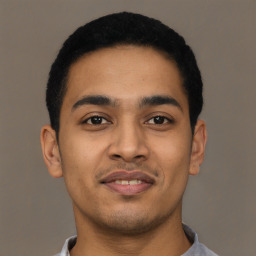 Joyful latino young-adult male with short  brown hair and brown eyes