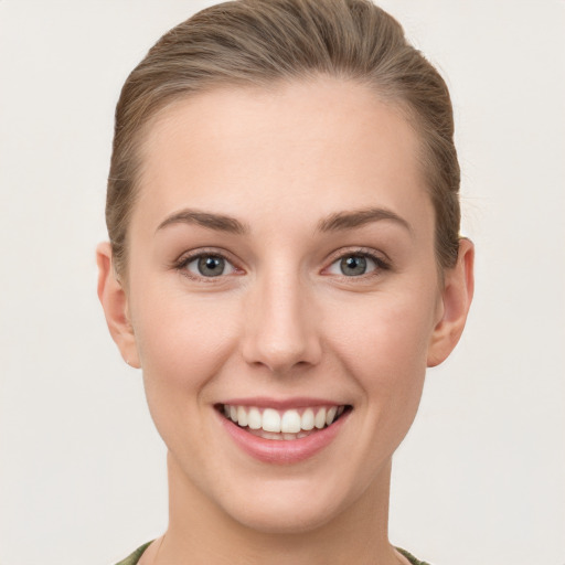 Joyful white young-adult female with short  brown hair and grey eyes