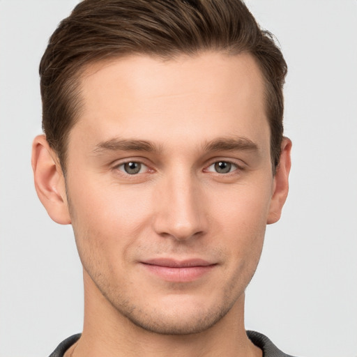 Joyful white young-adult male with short  brown hair and grey eyes