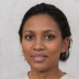 Joyful black adult female with medium  brown hair and brown eyes