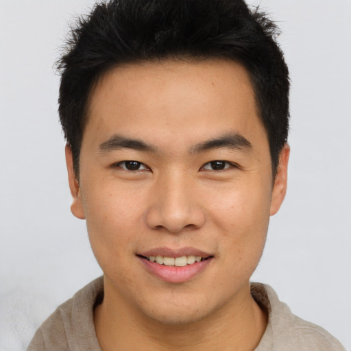Joyful asian young-adult male with short  brown hair and brown eyes