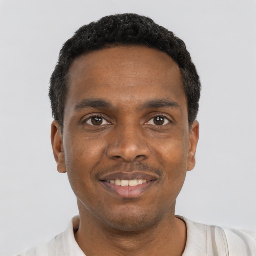 Joyful black young-adult male with short  black hair and brown eyes