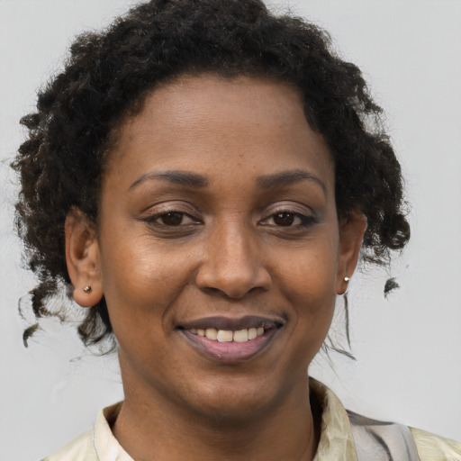 Joyful black young-adult female with short  brown hair and brown eyes
