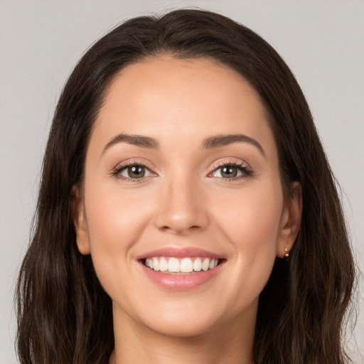 Joyful white young-adult female with long  brown hair and brown eyes