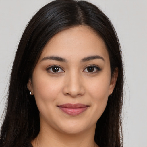 Joyful latino young-adult female with long  brown hair and brown eyes