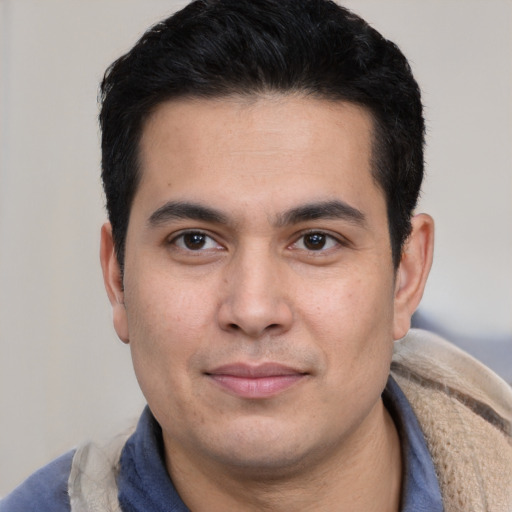 Joyful latino young-adult male with short  black hair and brown eyes