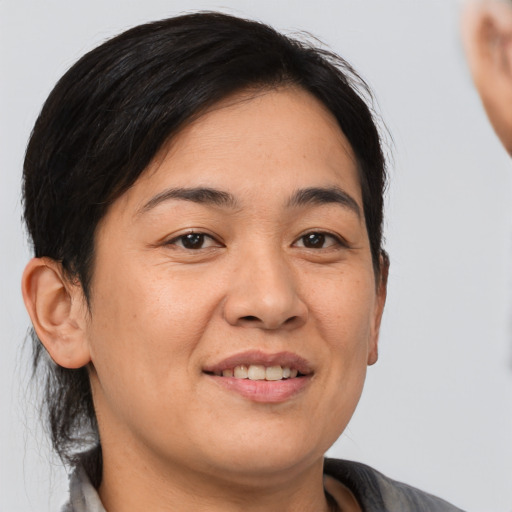 Joyful asian young-adult female with medium  brown hair and brown eyes