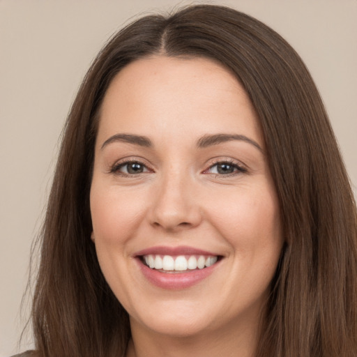 Joyful white young-adult female with long  brown hair and brown eyes