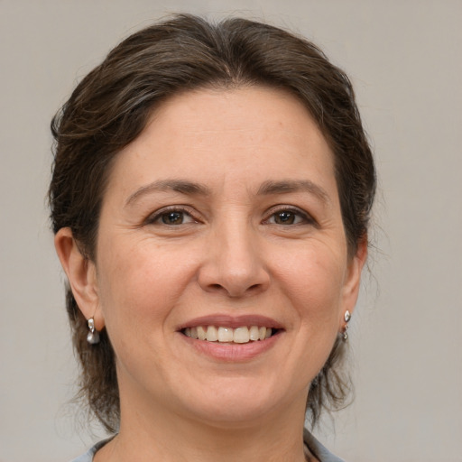 Joyful white adult female with medium  brown hair and grey eyes