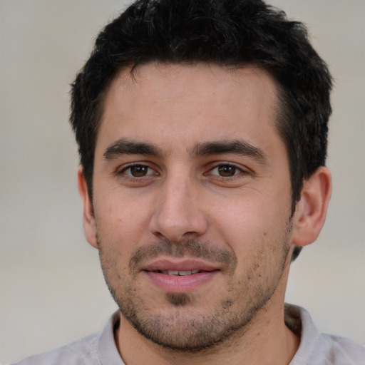 Joyful white young-adult male with short  black hair and brown eyes