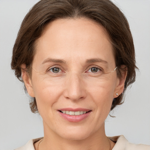 Joyful white adult female with medium  brown hair and grey eyes