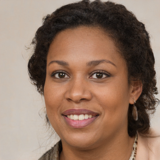 Joyful black young-adult female with medium  brown hair and brown eyes