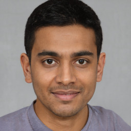 Joyful latino young-adult male with short  brown hair and brown eyes