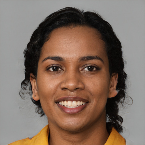 Joyful black young-adult female with medium  black hair and brown eyes