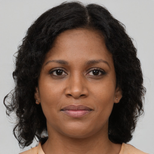 Joyful black young-adult female with medium  brown hair and brown eyes