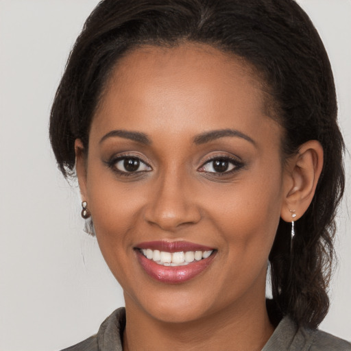 Joyful black young-adult female with long  brown hair and brown eyes