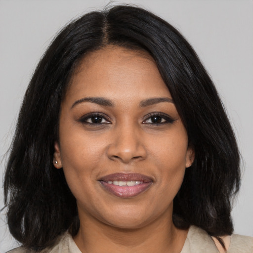Joyful black young-adult female with medium  black hair and brown eyes