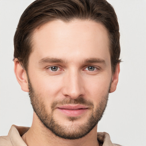 Joyful white young-adult male with short  brown hair and grey eyes