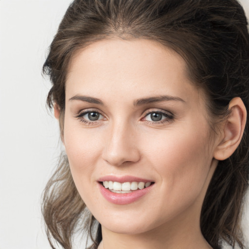 Joyful white young-adult female with medium  brown hair and grey eyes