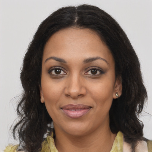 Joyful black young-adult female with long  brown hair and brown eyes