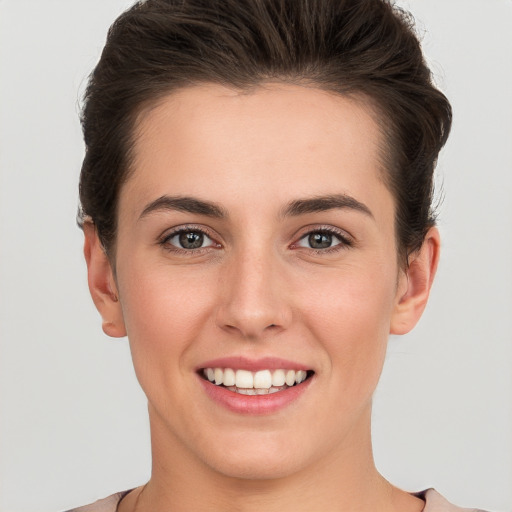 Joyful white young-adult female with short  brown hair and brown eyes