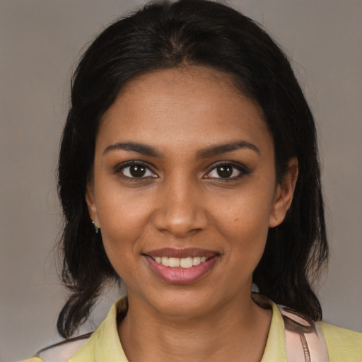 Joyful black young-adult female with medium  brown hair and brown eyes