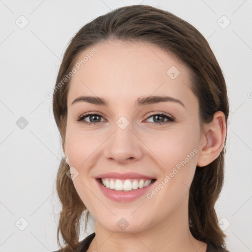 Joyful white young-adult female with long  brown hair and grey eyes