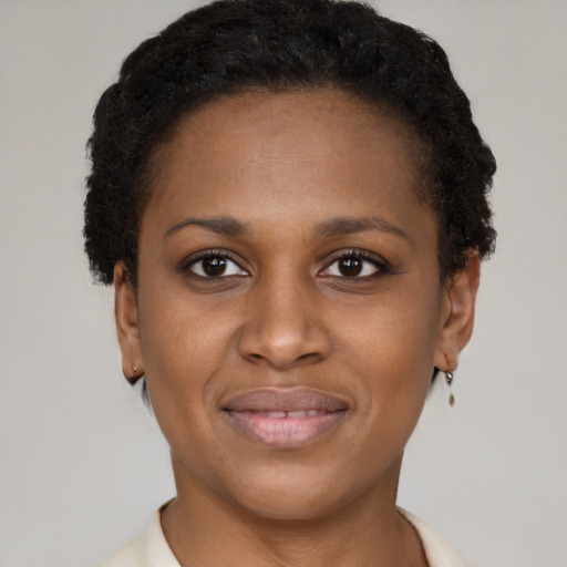 Joyful black young-adult female with short  brown hair and brown eyes