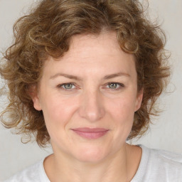 Joyful white young-adult female with medium  brown hair and blue eyes