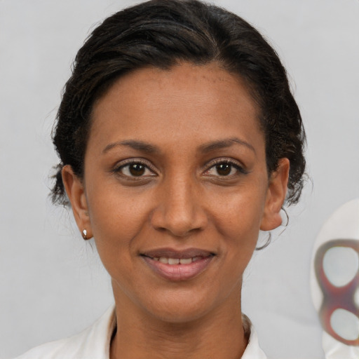 Joyful latino adult female with short  brown hair and brown eyes