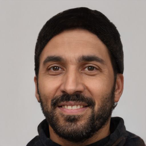 Joyful latino young-adult male with short  black hair and brown eyes