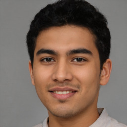Joyful latino young-adult male with short  black hair and brown eyes