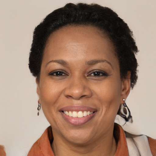 Joyful black adult female with short  brown hair and brown eyes