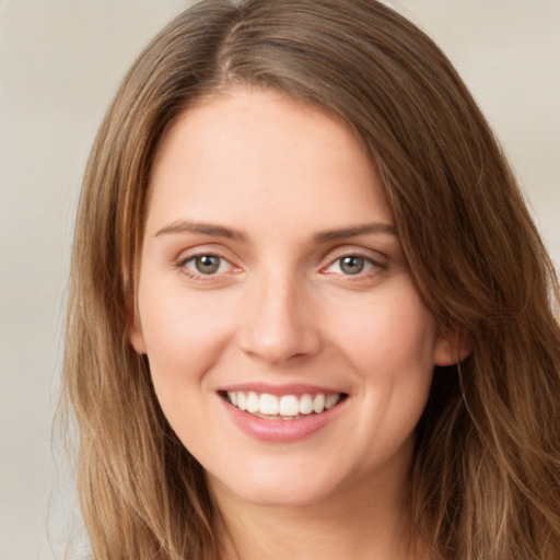 Joyful white young-adult female with long  brown hair and green eyes