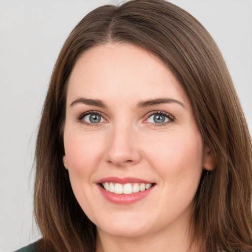 Joyful white young-adult female with long  brown hair and green eyes