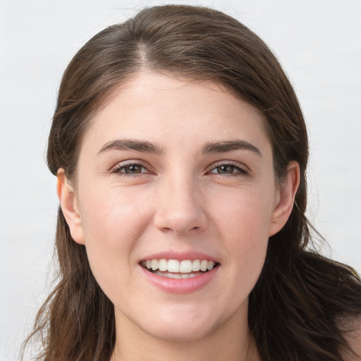 Joyful white young-adult female with long  brown hair and grey eyes