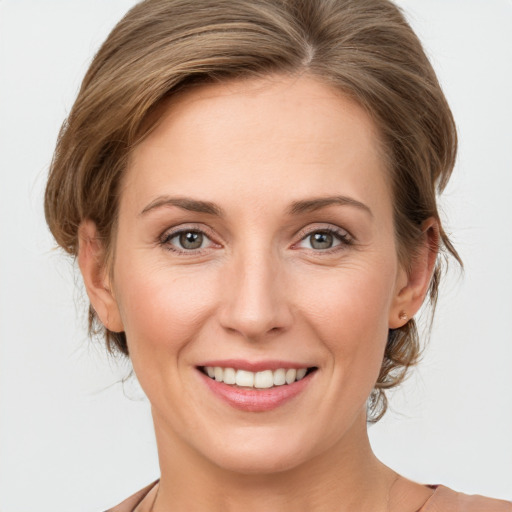 Joyful white young-adult female with medium  brown hair and grey eyes