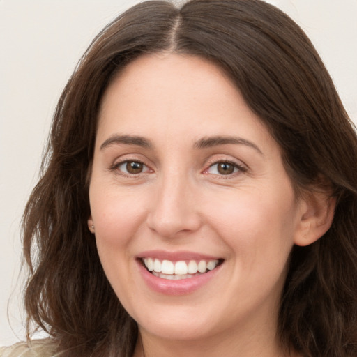 Joyful white young-adult female with long  brown hair and brown eyes